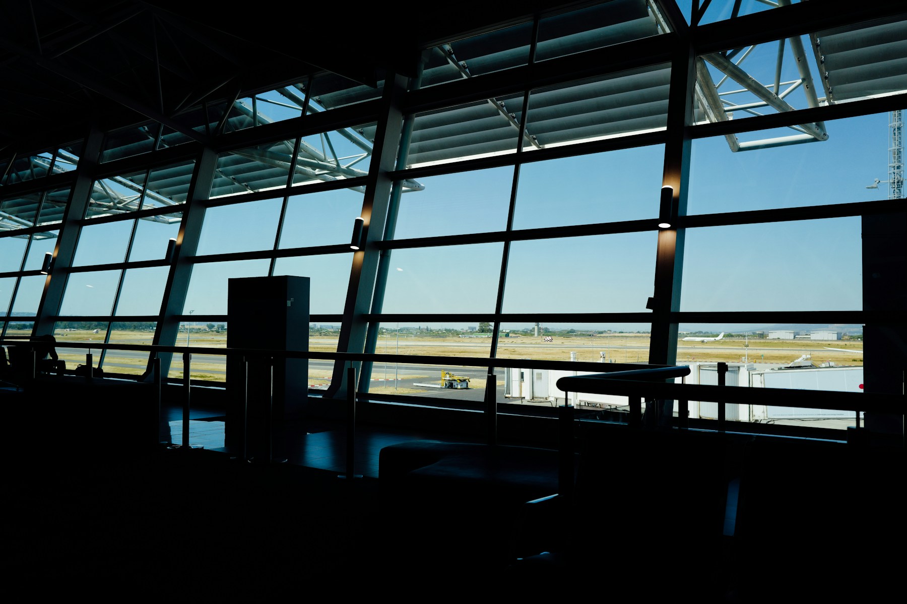 Generic airport concourse overlooking a sunlit tarmac