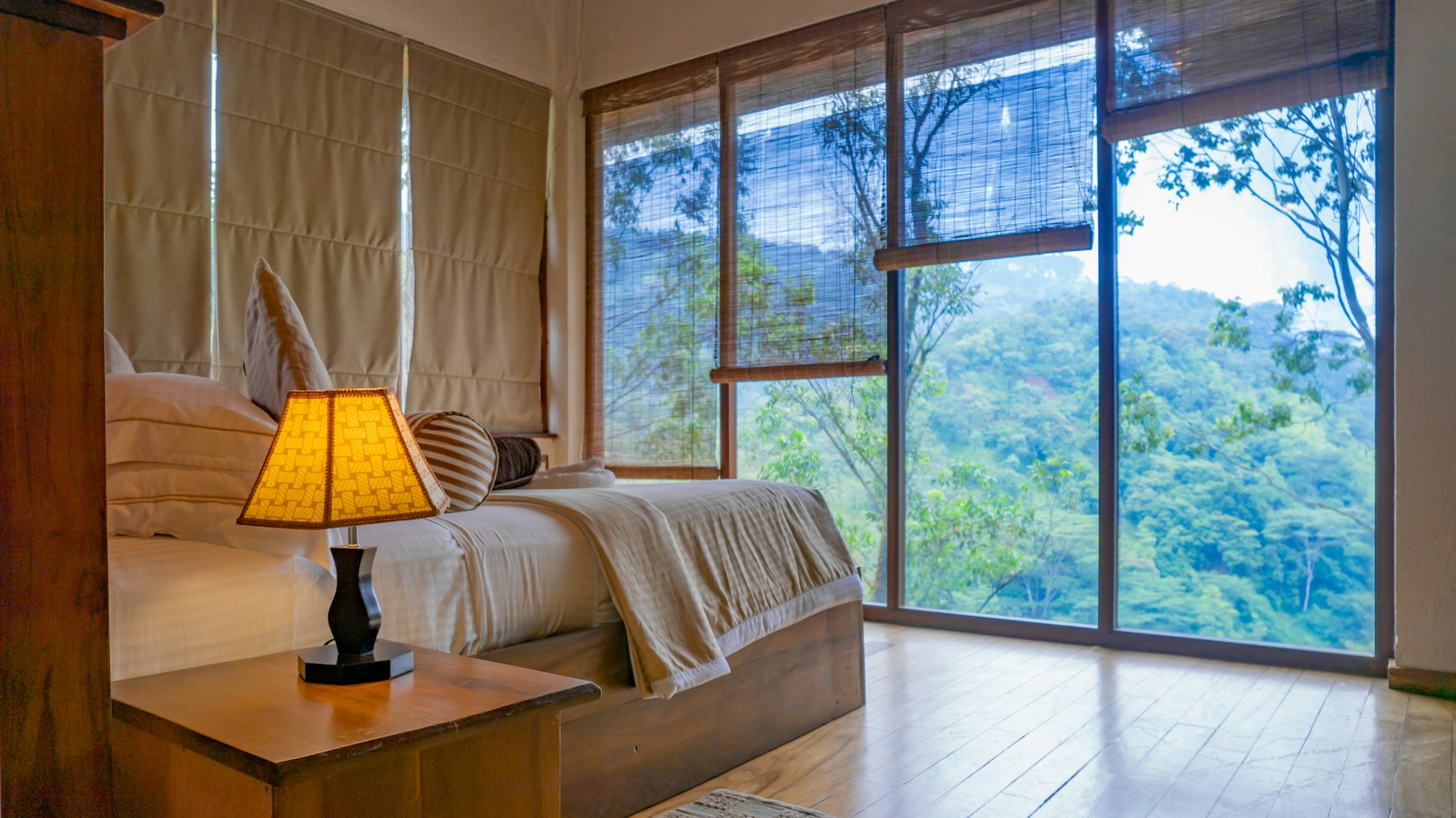Generic hotel bedroom with daylight through large windows